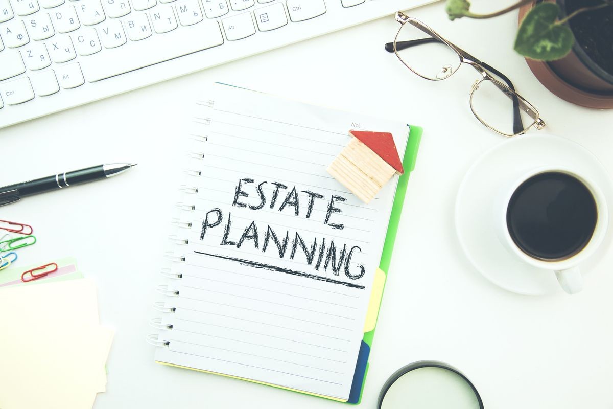 Estate Planning text on notepad and house model  on office desk